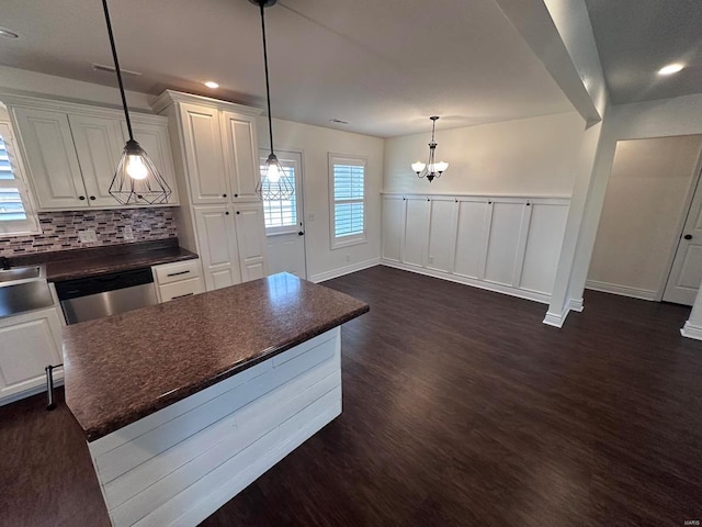 kitchen with dark countertops, dark wood-type flooring, a chandelier, white cabinets, and recessed lighting
