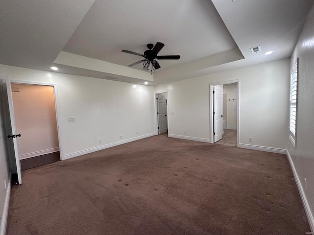 carpeted empty room featuring a tray ceiling, baseboards, recessed lighting, and ceiling fan