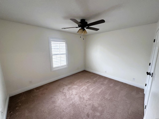 empty room with a ceiling fan, carpet, and baseboards