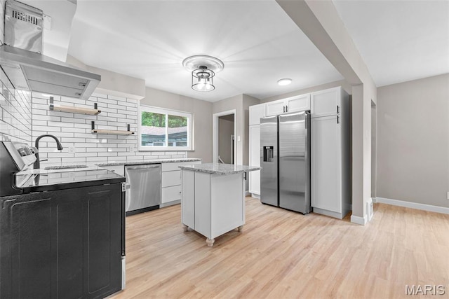 1247 Charlane Ct, Saint Louis, MO 63119 - kitchen featuring appliances with stainless steel finishes, open shelves, ventilation hood, decorative backsplash, and light wood-style floors