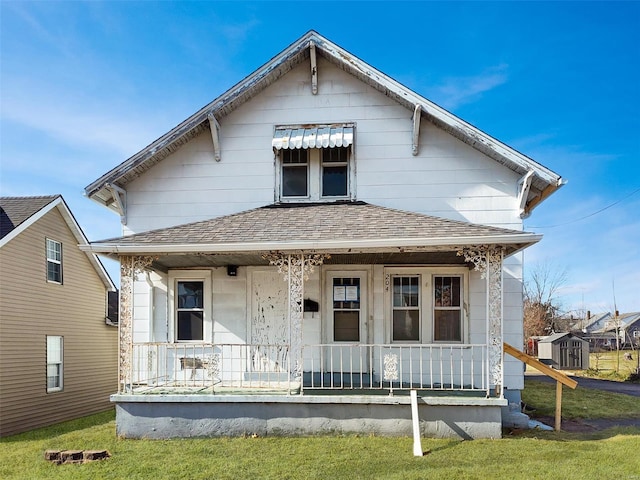 204 N W St, Perryville, MO 63775 - shotgun-style home with a porch, roof with shingles, and a storage shed