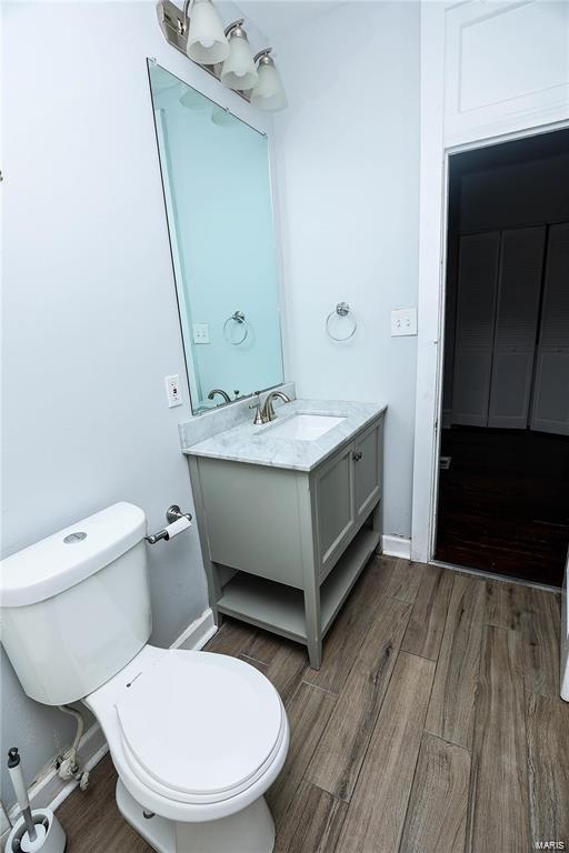 4220 Cleveland Ave, Saint Louis, MO 63110 - bathroom featuring toilet, wood finished floors, and vanity