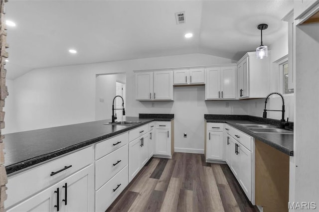 18211 State Highway J, Malden, MO 63863 - kitchen featuring a sink, vaulted ceiling, dark wood-style flooring, white cabinets, and dark countertops