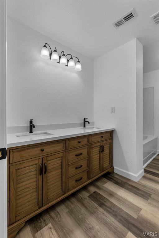 18211 State Highway J, Malden, MO 63863 - bathroom with wood finished floors, double vanity, baseboards, and a tub