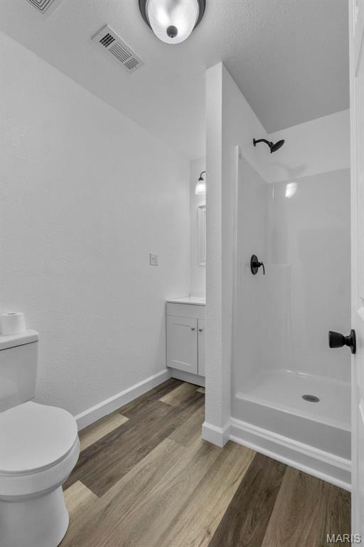 18211 State Highway J, Malden, MO 63863 - full bath with wood finished floors, vanity, walk in shower, and toilet
