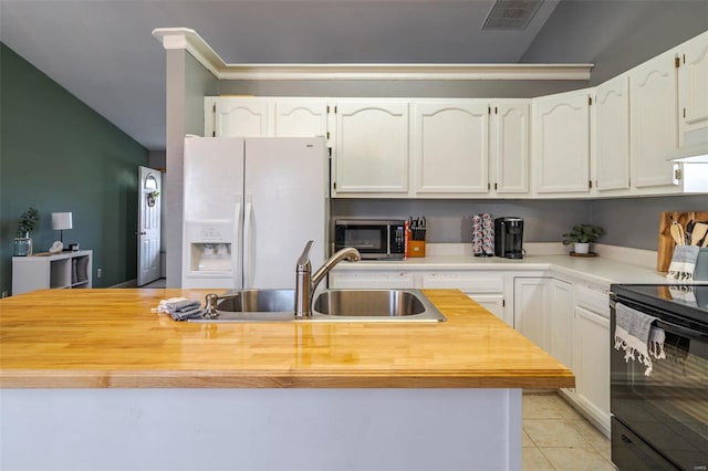 kitchen with white refrigerator with ice dispenser, a sink, black electric range, butcher block counters, and stainless steel microwave