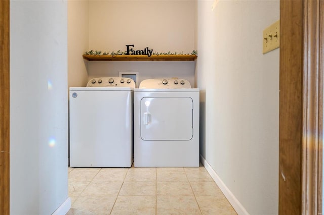 laundry room with separate washer and dryer, light tile patterned flooring, and baseboards