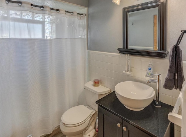 2571 Boyle Ave, Granite City, IL 62040 - bathroom with toilet, vanity, tile walls, a wainscoted wall, and curtained shower