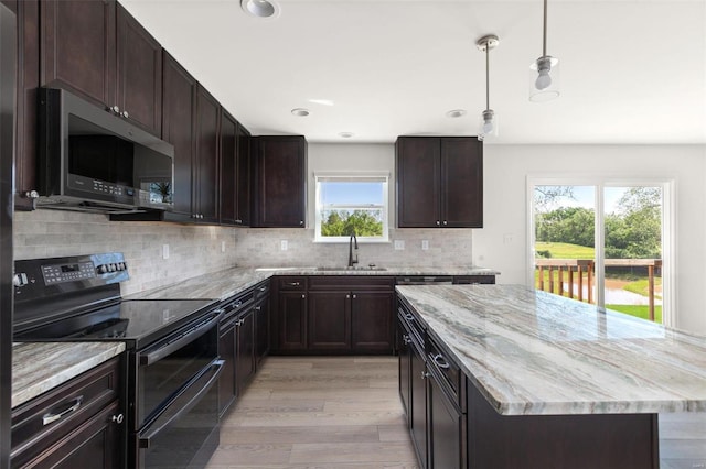 317 Winding Bluffs Ct, Fenton, MO 63026 - kitchen featuring range with two ovens, stainless steel microwave, a sink, light wood-style flooring, and light stone counters