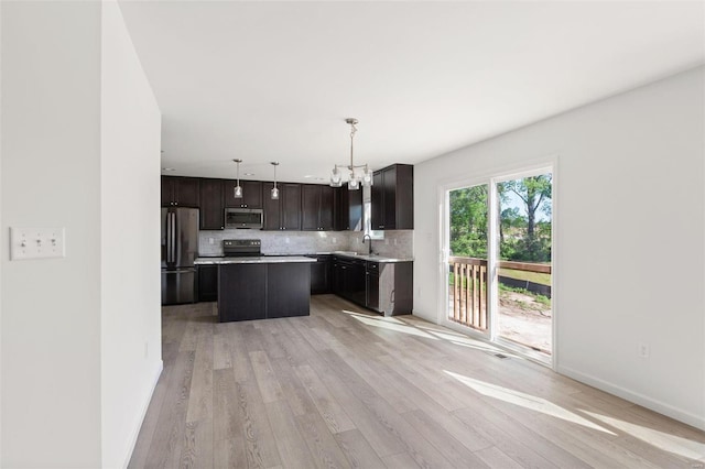 317 Winding Bluffs Ct, Fenton, MO 63026 - kitchen with appliances with stainless steel finishes, a sink, light wood finished floors, and backsplash