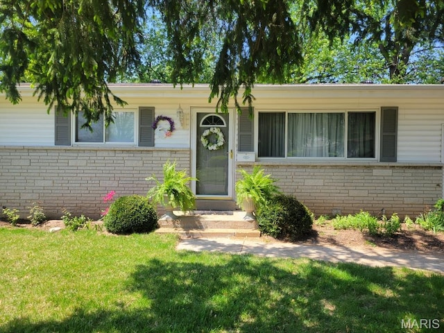 view of front of house with brick siding and a front lawn