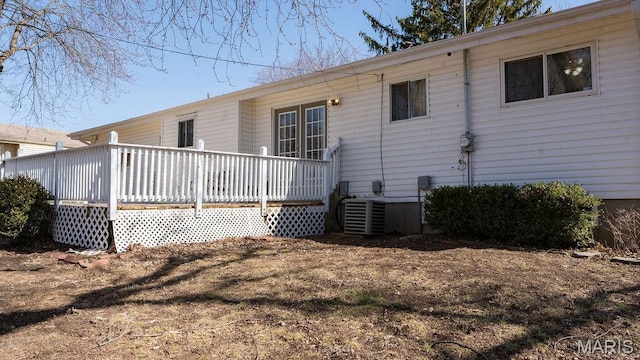 rear view of property with a wooden deck and cooling unit