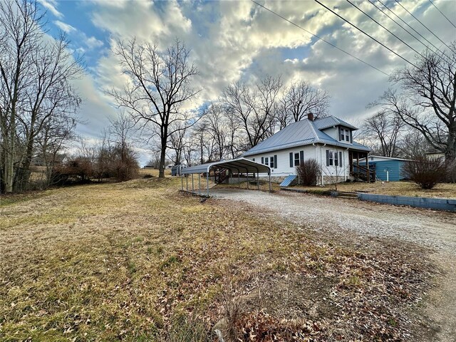 807 E 4th St, Salem, MO 65560 - view of front facade featuring a carport, driveway, metal roof, and a front yard