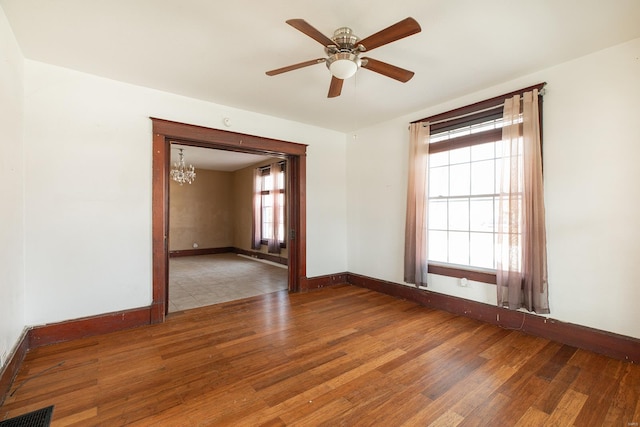 204 S Railroad St, Medora, IL 62063 - empty room with wood finished floors, baseboards, a chandelier, and a ceiling fan