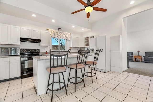 kitchen with black electric range, under cabinet range hood, white fridge with ice dispenser, recessed lighting, and a kitchen breakfast bar