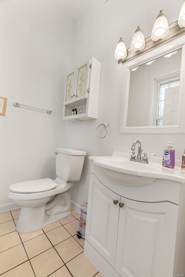 bathroom featuring toilet, baseboards, tile patterned flooring, and vanity