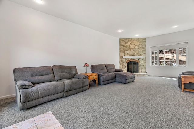 carpeted living area featuring baseboards, recessed lighting, and a stone fireplace