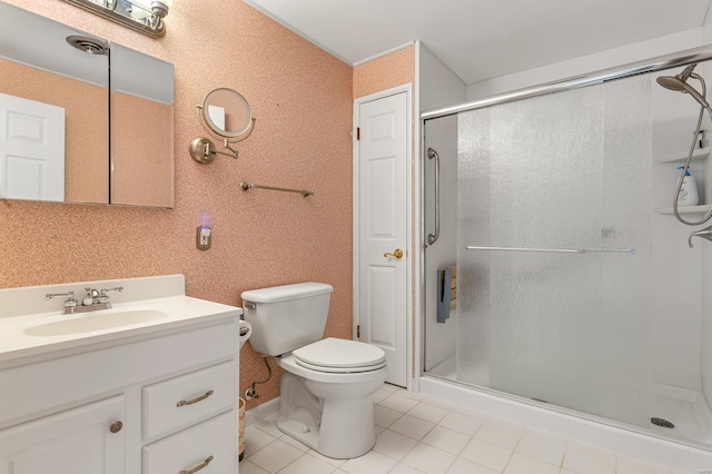 bathroom featuring a stall shower, toilet, vanity, and tile patterned floors