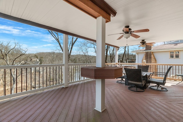 wooden deck featuring outdoor dining space and a ceiling fan