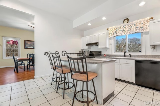 956 Long Bow Dr, Marthasville, MO 63357 - kitchen featuring black appliances, under cabinet range hood, a kitchen breakfast bar, healthy amount of natural light, and recessed lighting