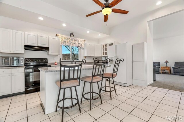 956 Long Bow Dr, Marthasville, MO 63357 - kitchen with black range with electric stovetop, white refrigerator with ice dispenser, under cabinet range hood, a kitchen breakfast bar, and ceiling fan