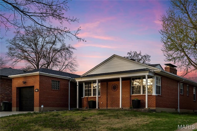 5816 Jamieson Ave, Saint Louis, MO 63109 - view of front of house with brick siding, an attached garage, a front lawn, and a chimney