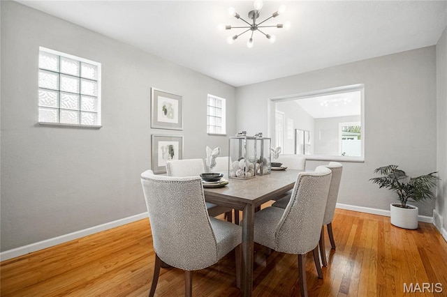 5816 Jamieson Ave, Saint Louis, MO 63109 - dining space featuring a chandelier, light wood-type flooring, baseboards, and healthy amount of natural light