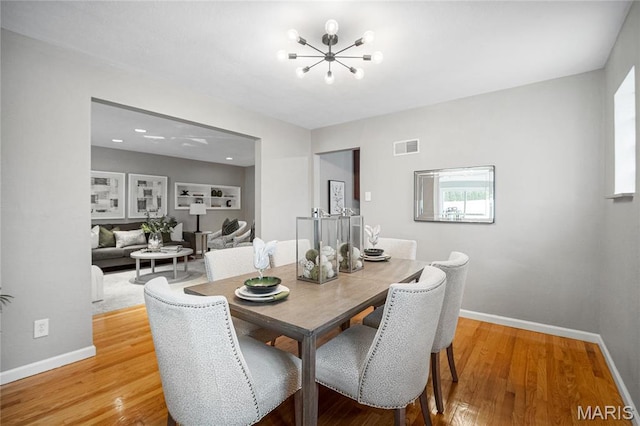 5816 Jamieson Ave, Saint Louis, MO 63109 - dining space featuring a chandelier, light wood-style flooring, and baseboards