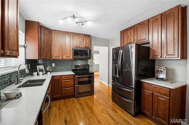 5816 Jamieson Ave, Saint Louis, MO 63109 - kitchen with stainless steel appliances, a sink, light wood finished floors, tasteful backsplash, and light countertops