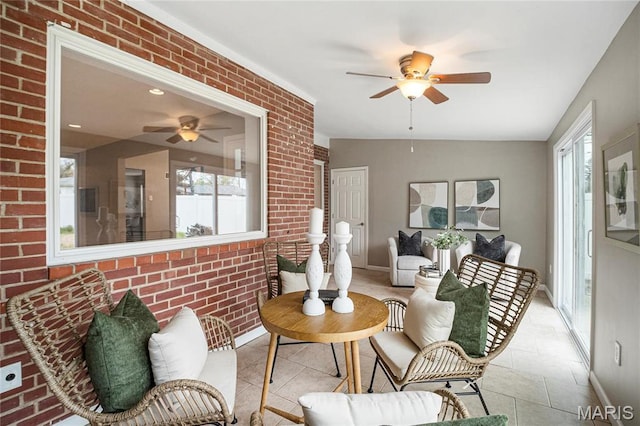 5816 Jamieson Ave, Saint Louis, MO 63109 - tiled living area featuring ceiling fan, plenty of natural light, brick wall, and baseboards
