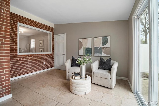 5816 Jamieson Ave, Saint Louis, MO 63109 - living area featuring baseboards, light tile patterned floors, and brick wall