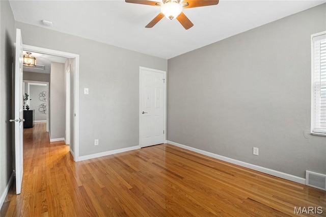 5816 Jamieson Ave, Saint Louis, MO 63109 - unfurnished bedroom featuring baseboards, wood finished floors, ceiling fan, and multiple windows