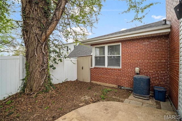 5816 Jamieson Ave, Saint Louis, MO 63109 - view of property exterior with fence, brick siding, a patio area, and roof with shingles