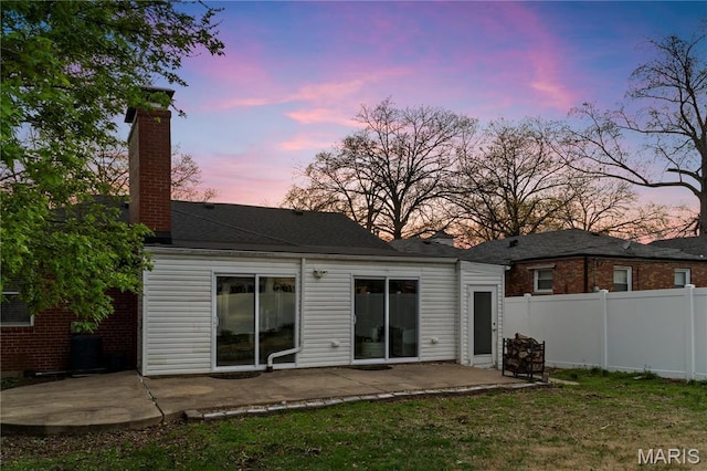 5816 Jamieson Ave, Saint Louis, MO 63109 - back of property at dusk with a patio area and a chimney
