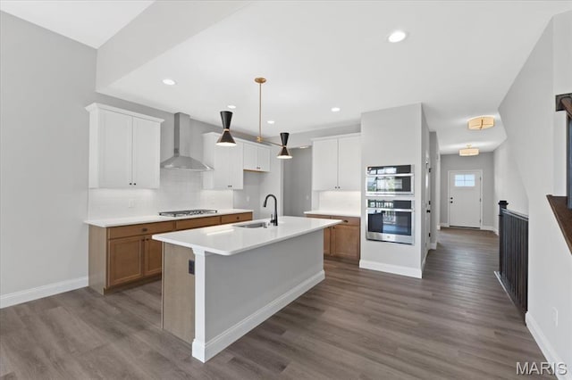 400 Thomlin Ct, Ofallon, MO 63367 - kitchen featuring wall chimney exhaust hood, backsplash, stainless steel appliances, light countertops, and an island with sink