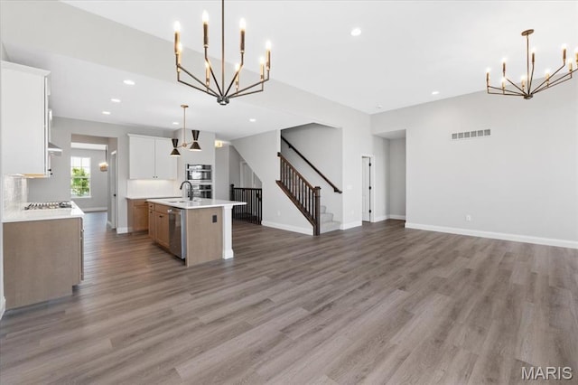 400 Thomlin Ct, Ofallon, MO 63367 - kitchen with a chandelier, open floor plan, stainless steel appliances, light countertops, and an island with sink
