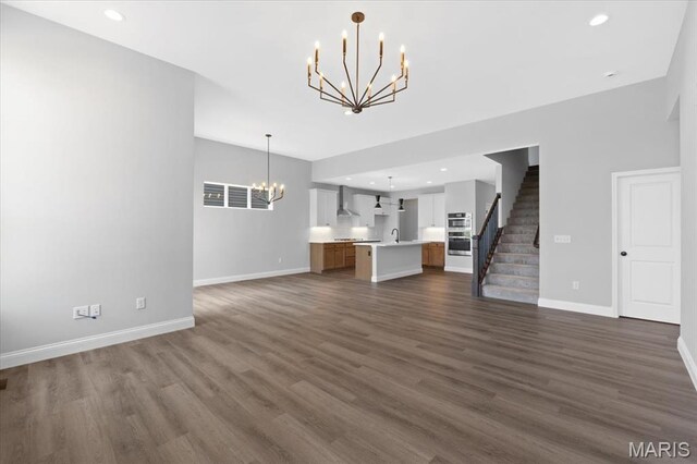 400 Thomlin Ct, Ofallon, MO 63367 - unfurnished living room featuring a chandelier, dark wood-style floors, stairway, and recessed lighting