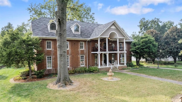 1011 N Ranney St, Sikeston, MO 63801 - view of front facade with a balcony, brick siding, covered porch, and a front yard