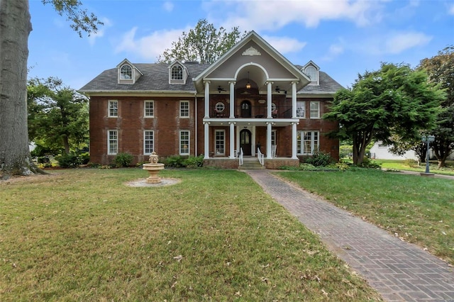 1011 N Ranney St, Sikeston, MO 63801 - neoclassical / greek revival house with a ceiling fan, brick siding, a porch, and a front yard