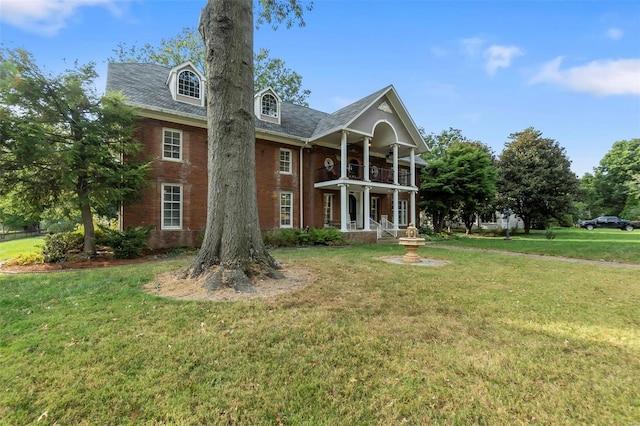 1011 N Ranney St, Sikeston, MO 63801 - view of front of house featuring a balcony, a front yard, and brick siding