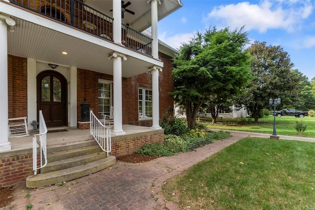 1011 N Ranney St, Sikeston, MO 63801 - view of exterior entry with brick siding, a balcony, covered porch, and a yard