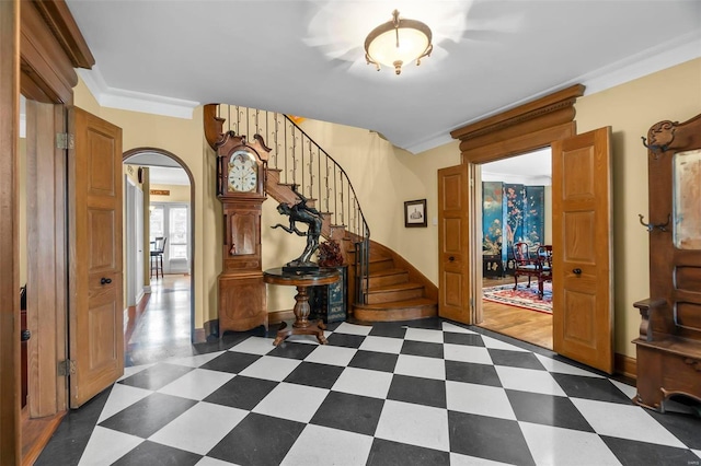 1011 N Ranney St, Sikeston, MO 63801 - foyer entrance with arched walkways, dark flooring, stairs, baseboards, and ornamental molding