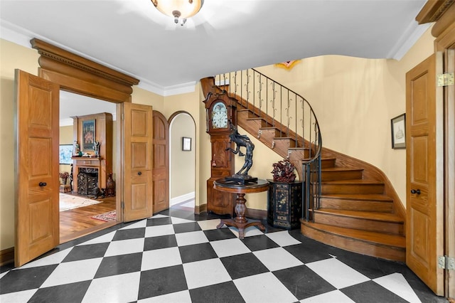 1011 N Ranney St, Sikeston, MO 63801 - entrance foyer featuring arched walkways, dark flooring, stairs, baseboards, and ornamental molding