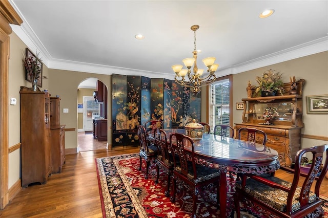 1011 N Ranney St, Sikeston, MO 63801 - dining area with arched walkways, a chandelier, crown molding, wood finished floors, and baseboards