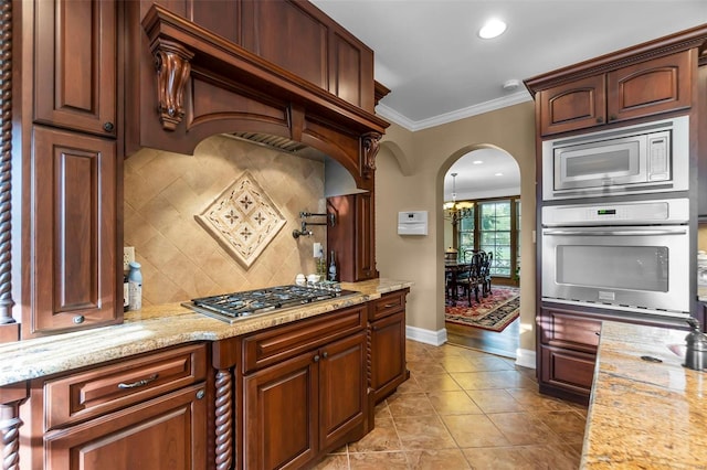 1011 N Ranney St, Sikeston, MO 63801 - kitchen with appliances with stainless steel finishes, arched walkways, decorative backsplash, ornamental molding, and baseboards
