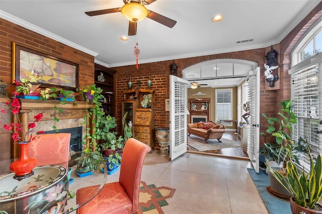 1011 N Ranney St, Sikeston, MO 63801 - living area with a fireplace, a ceiling fan, brick wall, ornamental molding, and speckled floor