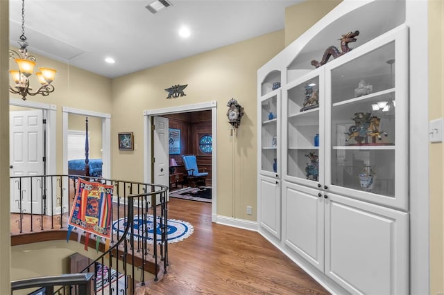 1011 N Ranney St, Sikeston, MO 63801 - corridor with an upstairs landing, wood finished floors, a chandelier, baseboards, and attic access