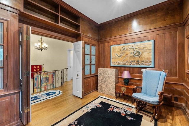 1011 N Ranney St, Sikeston, MO 63801 - sitting room featuring wood finished floors, a chandelier, wood walls, and ornamental molding