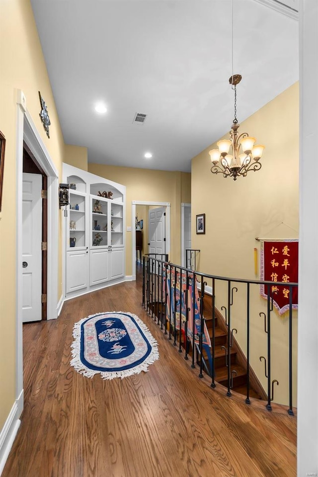 1011 N Ranney St, Sikeston, MO 63801 - corridor with wood finished floors, a chandelier, baseboards, and an upstairs landing