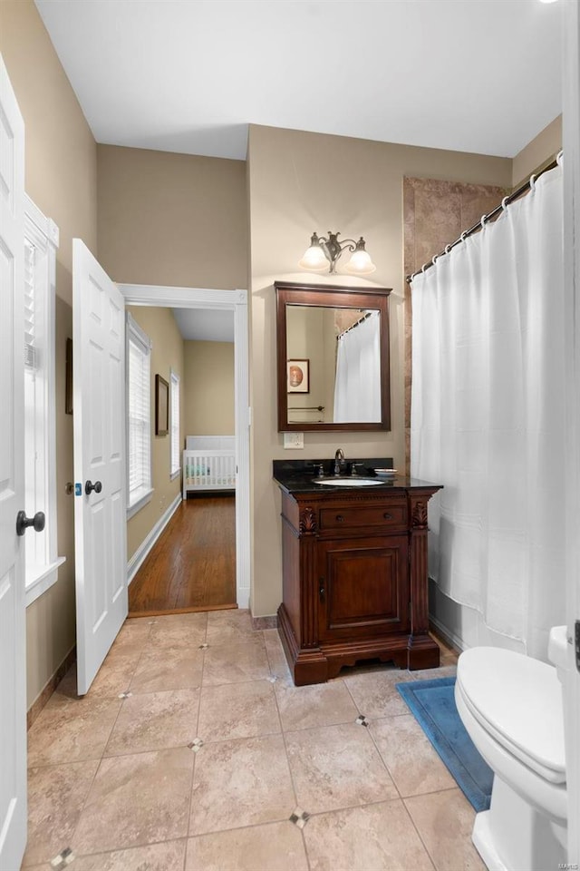1011 N Ranney St, Sikeston, MO 63801 - bathroom featuring toilet, vanity, baseboards, and tile patterned flooring
